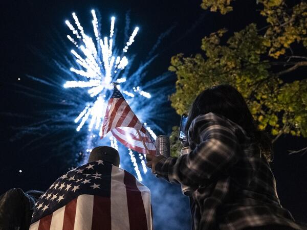Supporters of US President-elect Joe Biden watch fireworks as they celebrate near the White House on November 7, 2020 in Washington, D.C. Democrat Joe Biden urged unity on November 7 and promised "a new day for America" in his first national address since he won the tense US election and ended the historically turbulent and divisive era of Donald Trump. Alex Edelman / AFP