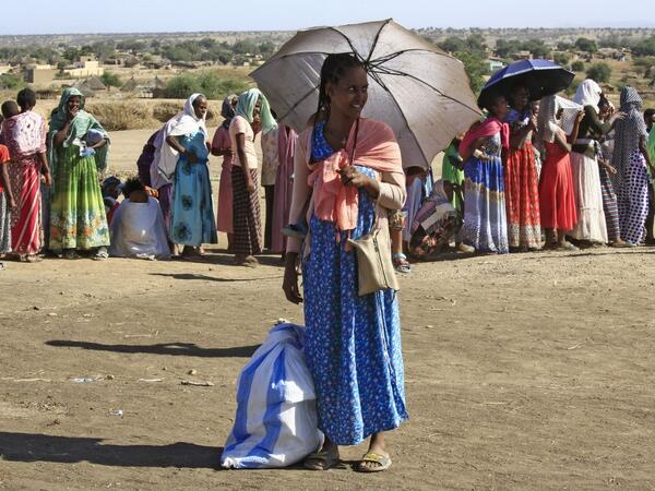 Ethiopian refugees who fled the fighting in the Tigray region gather upon arrival to a reception center in the Hamdayit area of Sudan's eastern Kassala state, on November 22, 2020. The placard reads "stop for inspection". ASHRAF SHAZLY / AFP