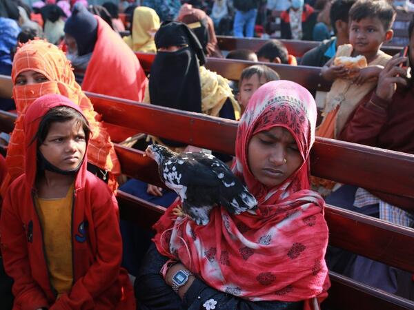 A Rohingya refugee holds a hen on a Bangladesh Navy ship as she sits with others being relocated to the controversial flood-prone island Bhashan Char in the Bay of Bengal, in Chittagong on December 29, 2020. Rehman ASAD / AFP