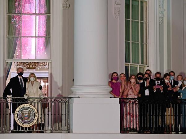 US President Joe Biden (L) and First Lady Jill Biden (2nd L) appear on the Blue Room Balcony as they and family members (R) watch fireworks from the White House in Washington, DC on January 20, 2021. JIM WATSON / AFP