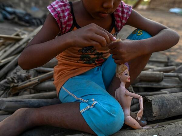This photo taken on January 11, 2021 shows a Chin child playing with a doll in Bethel village in Hmawbi, on the outskirts of Yangon, where hundreds of members of the Chin ethnic community have settled after being displaced by fighting between Myanmar's military and the Arakan Army in the country's north.  Ye Aung THU / AFP
