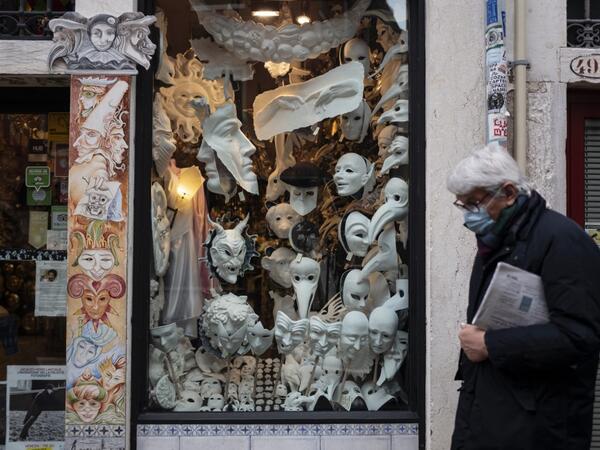 A man wearing a face mask walks past the shop and laboratory 'Ca del Sol' in Venice on February 6, 2021, as the traditional Venice carnival is being cancelled due to the Covid-19 pandemic. Marco Bertorello / AFP