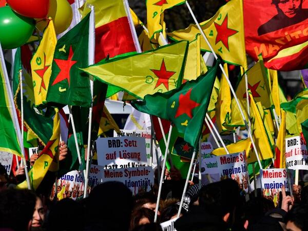 Protesters hold flags during a demonstration of Kurdish groups to protest against Turkey's offensive against Kurds in Syria's Afrin region, on Mar. 3, 2018 in Berlin.
(John MACDOUGALL / AFP)