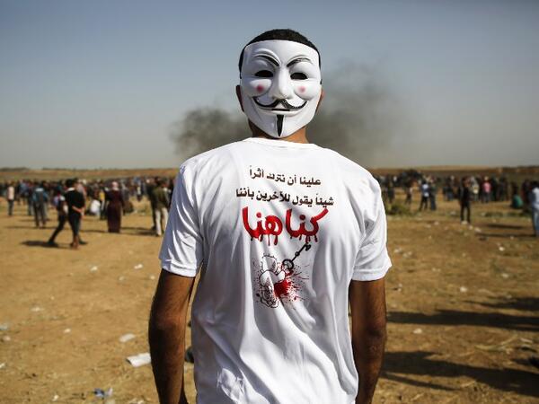 A Palestinian demonstrator wears a mask during clashes with Israeli security forces following a protest, on the Gaza-Israel border, east of Gaza City, on Apr. 6, 2018. 
(MOHAMMED ABED / AFP)
