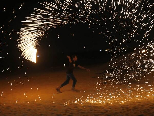 A Palestinian protester from a group calling themselves the "night confusion units" waves a sparkler near the Gaza-Israel border east of Rafah in the southern Gaza Strip, on September 26, 2018. 
SAID KHATIB / AFP