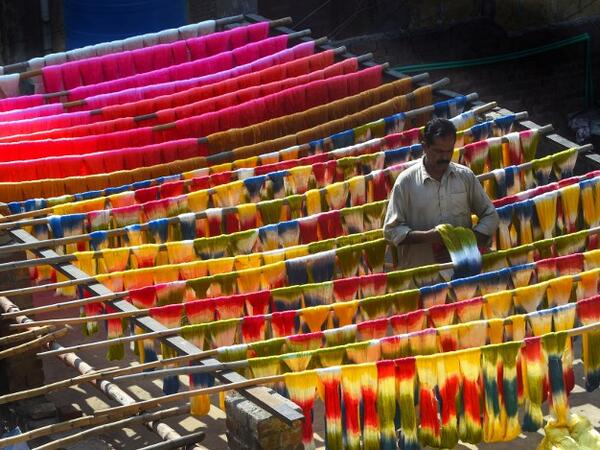 A Pakistani worker dries fabric threads after dyeing them at a factory in Lahore on February 11, 2019. 
ARIF ALI / AFP