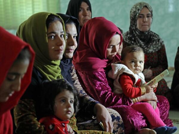 Women and young girls listen to Rasul an Iraqi Kurdish activist with the non-profit organisation WADI, as she peaks about the harms of genital mutilation in Sharboty Saghira.
SAFIN HAMED / AFP