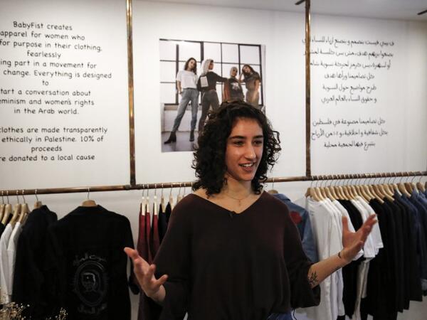 Palestinian fashion designer Yasmeen Mjalli speaks while standing in her clothing shop where her label collection "BabyFist" carrying anti-sexual harassment slogans is showcased, in Ramallah in the occupied West Bank 
ABBAS MOMANI / AFP