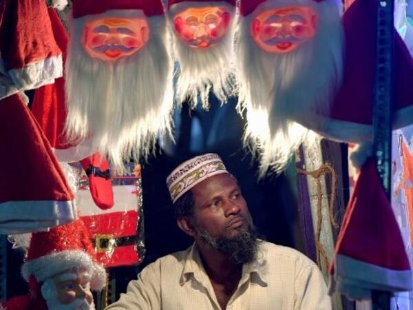 An Indian shopper arranges Santa Claus masks on display on a road side stall in Bangalore on December 19, 2018, ahead of the celebration of Christmas. 
MANJUNATH KIRAN / AFP
