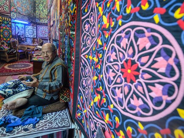 An Egyptian craftsman gestures as he sits while working on a tapestry in his shop in Khayamiya Street, or the Street of Tent-makers, in the old city of the Egyptian capital Cairo. Mohamed el-Shahed / AFP