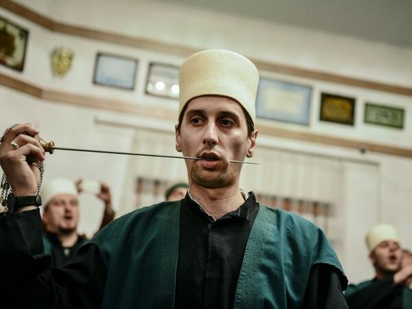 A Kosovo Dervish, an adept of Sufism, a mystical form of Islam, pierces his cheek with a needle during a ceremony in a prayer room in Gjakova
Gent SHKULLAKU / AFP