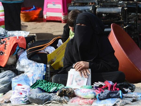 A displaced woman sells second hand items in the souk or market of Al-Hol camp for displaced people in northeastern Syria, which currently brims with more than 70,000 people, even though it was only designed to accommodate a seventh of that number. 
GIUSEPPE CACACE / AFP