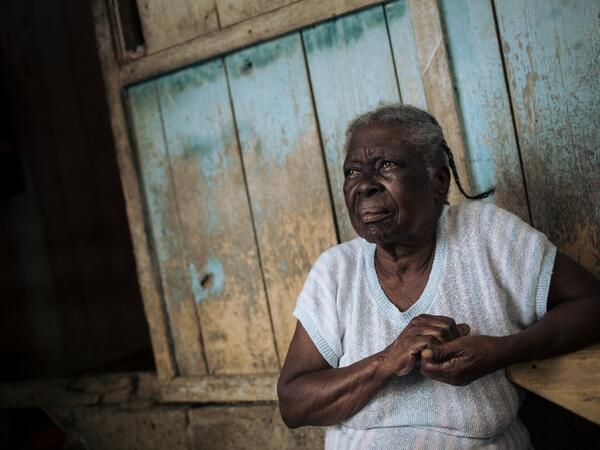 Agida Lucia, 89, sits in front of her house in the roca Agostinho Neto, an abandoned cocoa plantation of Sao Tome and Principe on May 29, 2019. Alexis HUGUET / AFP