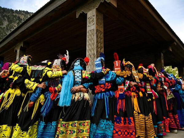 In this picture Kalash women wearing traditional dresses dance to celebrate 'Joshi', a festival to welcome the arrival of spring, at Bumburate village in the mountainous valleys in northern Pakistan. AAMIR QURESHI / AFP