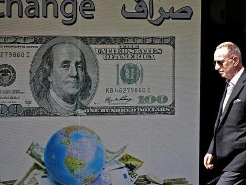 A man walks past a money exchange in Beirut after Lebanon's central bank announced measures to facilitate access to dollars for importers of petroleum products, wheat, and medicine amid fears of a dollar shortage.