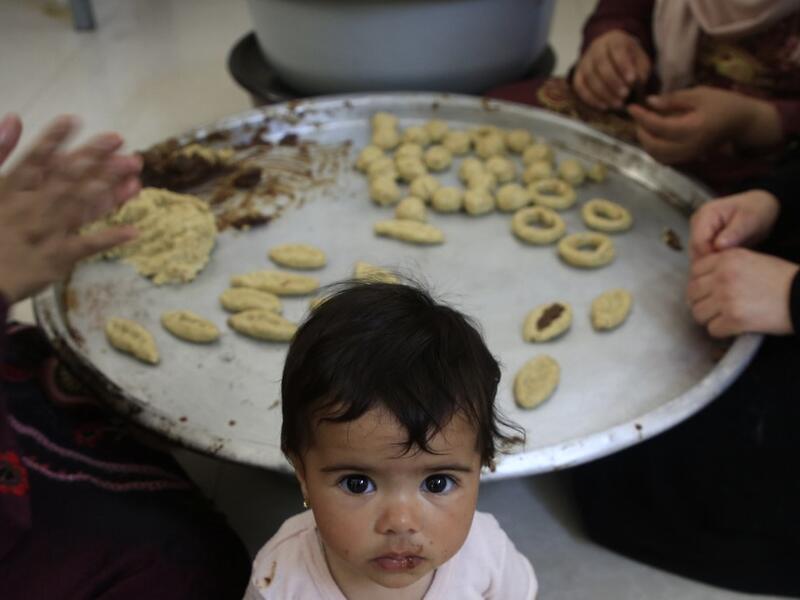Palestinian women prepare traditional cookies ahead of the Eid al-Fitr festivities, celebrating the end of the holy Muslim fasting month of Ramadan, in Beit Lahia in the northern Gaza Strip on May 29, 2019.  MOHAMMED ABED / AFP