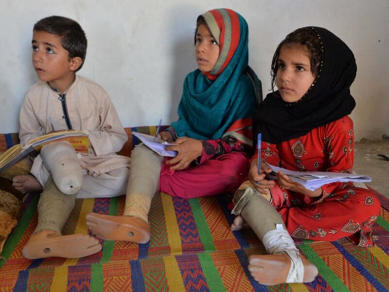 In this photograph taken on May 14, 2019, Hamisha Gul’s grandchildren, who lost their legs following unexploded rocket explosion, attend and study at a class in their house in Khogyani district of Nangarhar province. NOORULLAH SHIRZADA / AFP