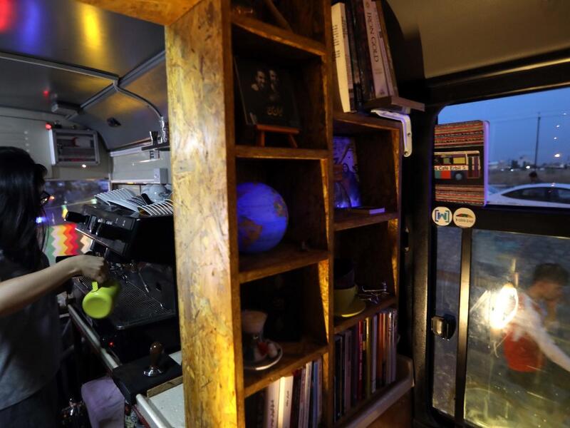 Kani Jalil, a 22-year-old Iraqi Kurdish woman who runs with her husband "The Bus Cafe Erbil" in Arbil, prepares a coffee for clients inside her cafe in Arbil, the capital of Iraq's Kurdish autonomous region, late on June 7, 2019, on the long weekend of the Eid al-Fitr holiday which marks the end of the Muslim holy month of Ramadan.  SAFIN HAMED / AFP