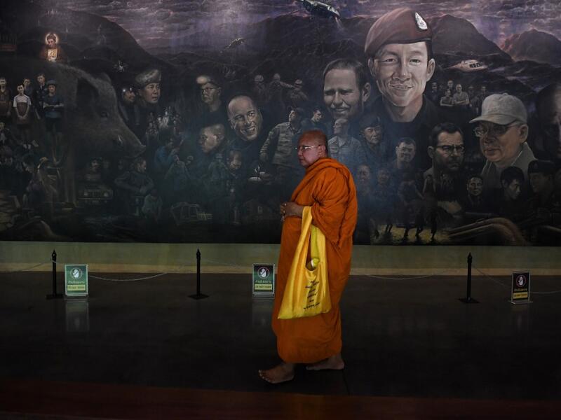 Tourists snap selfies by a bronze statue of the diver who died trying to save the 'Wild Boar' footballers from a flooded cave, while momentos from their rescue fly off the shelves -- scooped up by the 1.3 million people who have descended on a once serene mountainside in northern Thailand. Lillian SUWANRUMPHA / AFP