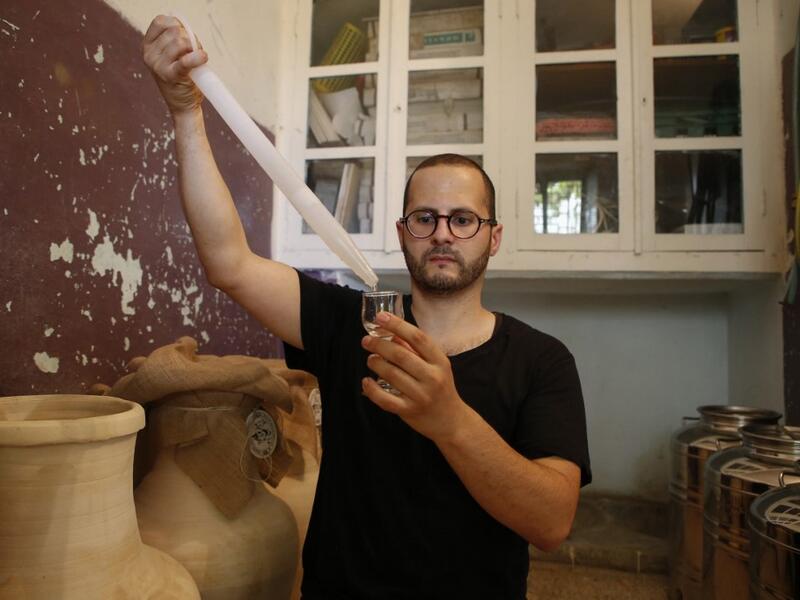 Palestinian distiller Nader Muaddi uses an alcoholometer to measure the amount of alcohol in his Arak in the West Bank village of Beit Jala, near Bethlehem, on June 16, 2019. In his basement, distiller Muaddi made fewer than 500 bottles of liquor last year, but it is earning global acclaim and reviving interest in the Palestinian alcohol sector. On the outskirts of the city famed for Jesus's birth, the 35-year-old illustrates the handcrafted way he makes Arak, an anise-flavoured drink popular in the Middle 