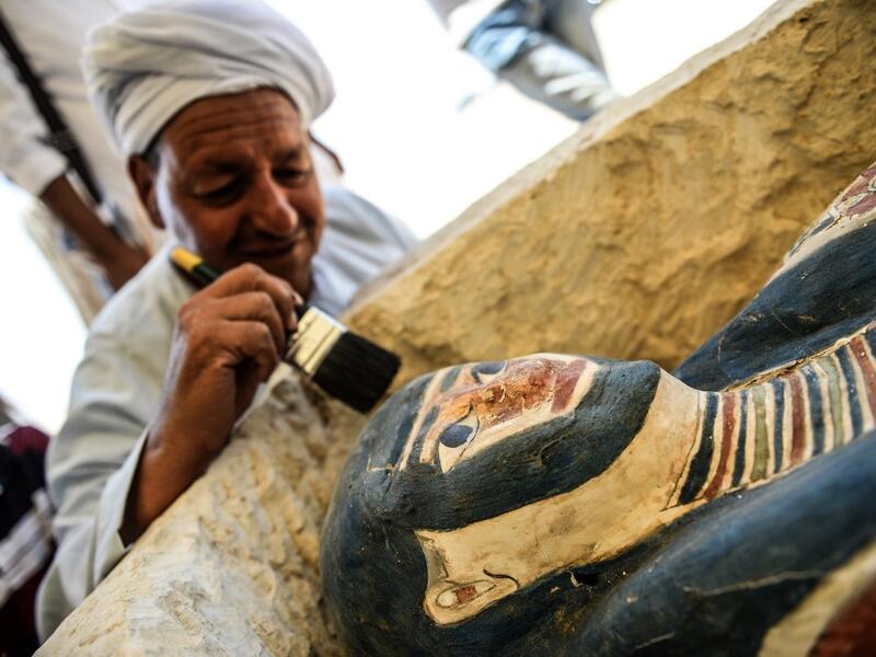 An Egyptian archaeological mission discovered a collection of stone, clay and wooden sarcophagi, of which some are still containing well preserved mummies, as well as a collection of wooden funerary masks and instruments used in cutting stones .  Mohamed el-Shahed / AFP
