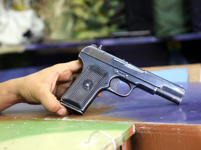 A Soviet-produced TT-33 pistol is pictured at a shop in Yemen's third city of Taez, on July 13, 2019. Before the war, the old market of Taez was crowded with people and full of handcrafts and artisanal goods. Today, more than four years after the Huthi rebels began their siege on Yemen's third largest city, bullets and guns have taken over the market. AHMAD AL-BASHA / AFP