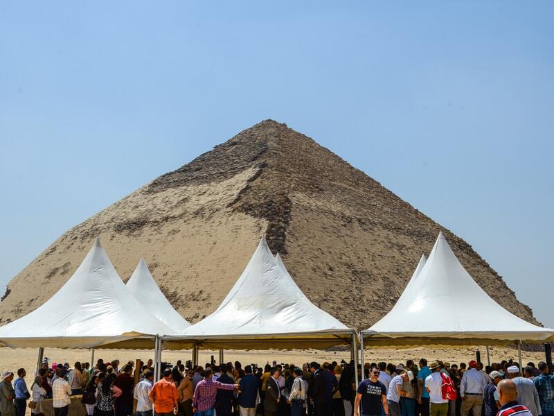 People gather during an inaugural ceremony in front of the Bent pyramid of King Sneferu, the first pharaoh of Egypt's 4th dynasty, in the ancient royal necropolis of Dahshur on the west bank of the Nile River, south of the capital Cairo on July 13, 2019. Mohamed el-Shahed / AFP