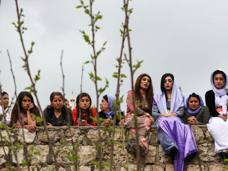 Iraqi Yazidi women sit outside the Temple of Lalish, in a valley near the Kurdish city of Dohuk about 430 kilometres northwest of the capital Baghdad, on April 16, 2019, during a ceremony marking the Yazidi New Year. SAFIN HAMED /
