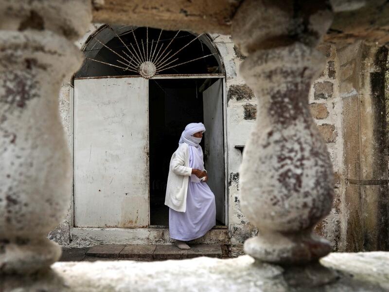 An Iraqi Yazidi visits the Temple of Lalish, in a valley near the Kurdish city of Dohuk about 430 kilometres northwest of the capital Baghdad, on April 16, 2019, during a ceremony marking the Yazidi New Year. Of the 550,000 Yazidis in Iraq before the Islamic State (IS) group invaded their region in 2014, around 100,000 have emigrated abroad and 360,000 remain internally displaced. Roughly 3,300 Yazidis have returned from IS captivity in the last five years, only 10 percent of them men. SAFIN HAMED / AFP