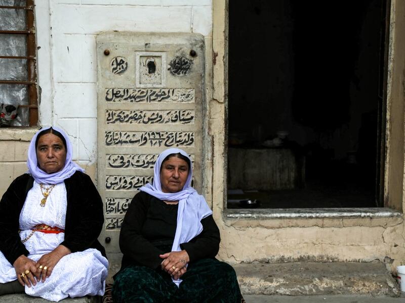 Iraqi Yazidi women sit outside the Temple of Lalish, in a valley near the Kurdish city of Dohuk about 430 kilometres northwest of the capital Baghdad, on April 16, 2019, during a ceremony marking the Yazidi New Year. Roughly 3,300 Yazidis have returned from IS captivity in the last five years, only 10 percent of them men. SAFIN HAMED /