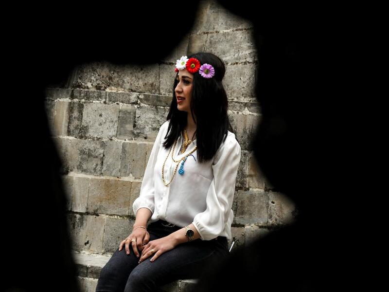 An Iraqi Yazidi woman sits outside the Temple of Lalish, in a valley near the Kurdish city of Dohuk about 430 kilometres northwest of the capital Baghdad, on April 16, 2019, during a ceremony marking the Yazidi New Year. Of the 550,000 Yazidis in Iraq before the Islamic State (IS) group invaded their region in 2014, around 100,000 have emigrated abroad and 360,000 remain internally displaced. Roughly 3,300 Yazidis have returned from IS captivity in the last five years, only 10 percent of them men. SAFIN HAM