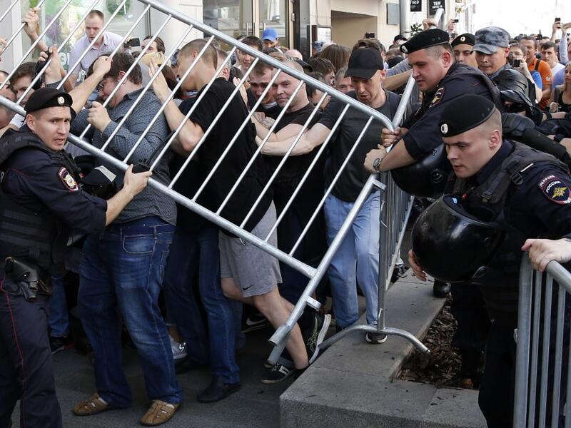 Protesters attempt to break through a police cordon during an unauthorised rally demanding independent and opposition candidates be allowed to run for office in local election in September, in downtown Moscow on July 27, 2019.  Maxim ZMEYEV / AFP