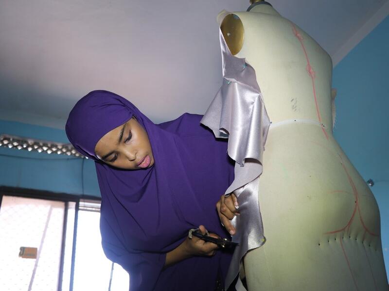 Muna Mohamed Abdullahi, 24 years old, owner of Mkena Designs, cuts some fabrics on a mannequin on November 4, 2018, in Mogadishu. Abdi HAJJI HUSSEIN / AFP