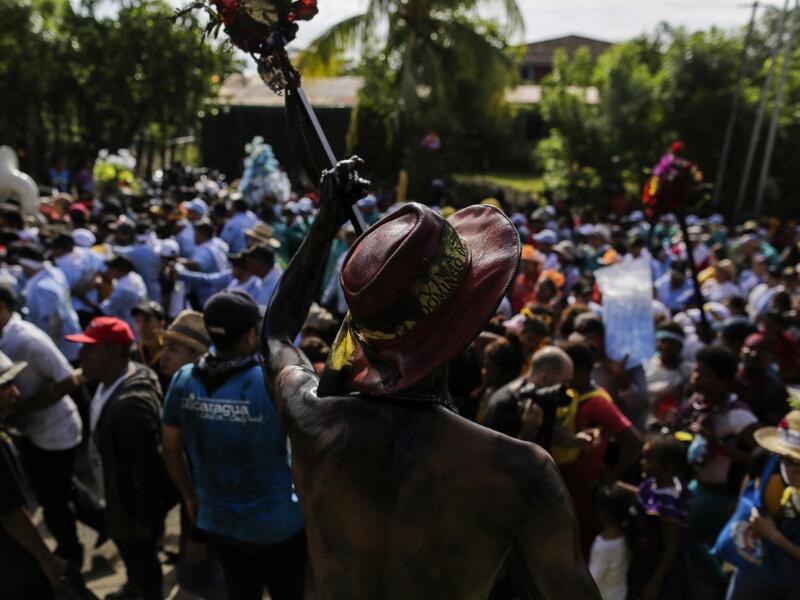 Catholic faithful smeared in burnt oil, take part in the opening of the ten-day celebration of the Santo Domingo de Guzman festival in Managua, on August 1, 2019.  INTI OCON / AFP