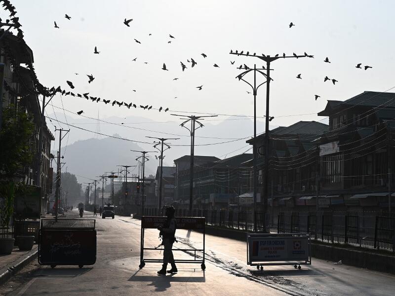 A security personnel stands guard at a roadblock during a curfew in Srinagar on August 6, 2019. India's home affairs minister on August 6 hailed "historic" legislation to bring Kashmir under its direct control, as New Delhi stepped up its clampdown on dissent in the restive Muslim-majority region. Tauseef MUSTAFA / AFP