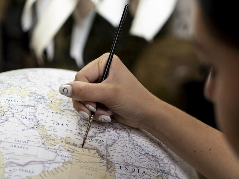 An artist applies paintwork to a globe at the Bellerby and Co Globemakers' workshop and headquarters in Stoke Newington in north London, on July 19, 2019. Niklas HALLE'N / AFP