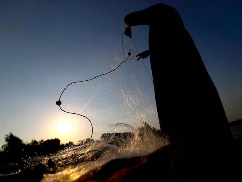 An Egyptian Fisherman holds a fishing net on the waters of the Pharaonic Sea in the village of Kafr Fisha, province of Monufia, on August 13, 2019. Mohamed el-Shahed / AFP