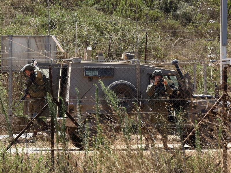 Lebanese village of Kfar Kila shows Israeli soldiers behind the border fence in the Israeli village of Mutella. (Mahmoud ZAYYAT / AFP)