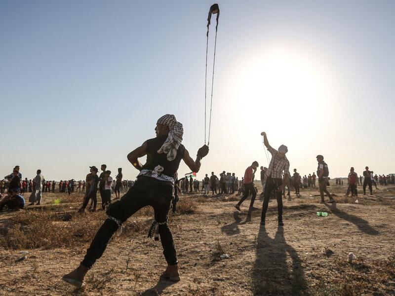 A Palestinian protester uses a slingshot to hurl stones during clashes with Israeli forces near the fence along the border with Israel in the eastern Gaza Strip on August 16, 2019.  (MAHMUD HAMS / AFP)