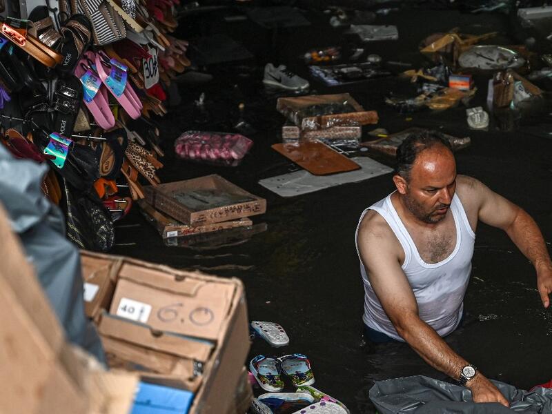 A shop owner tries to save his belongings in a flooded undergate shop center on August 17, 2019 in Eminonu district in Istanbul, after a heavy rainfall. Ozan KOSE / AFP