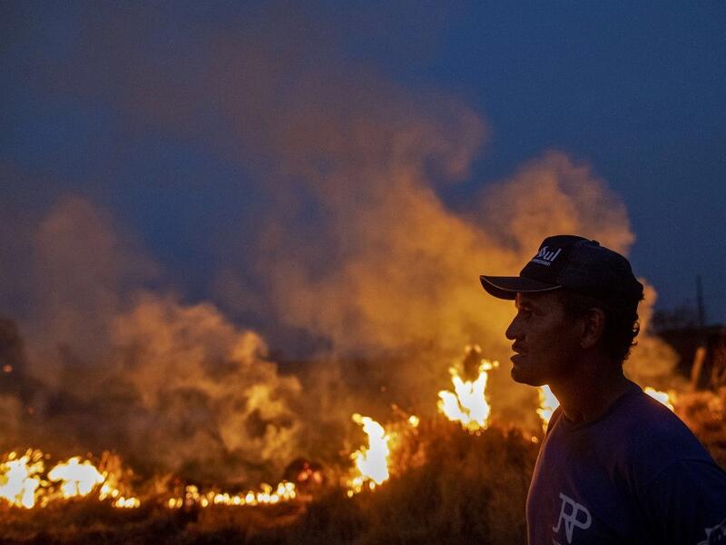 A labourer stares at a fire that spread to the farm he work on next to a highway in Nova Santa Helena municipality in northern Mato Grosso State, south in the Amazon basin in Brazil, on August 23, 2019. (AFP/ File Photo)