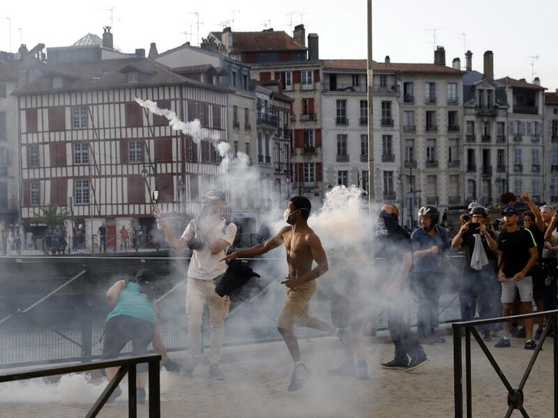 A protester lobs a 'canister' back towards French security personnel during a demonstration in the city of Bayonne, south-west France on August 24, 2019, on the sidelines of the annual G7 Summit. Thomas SAMSON / AFP