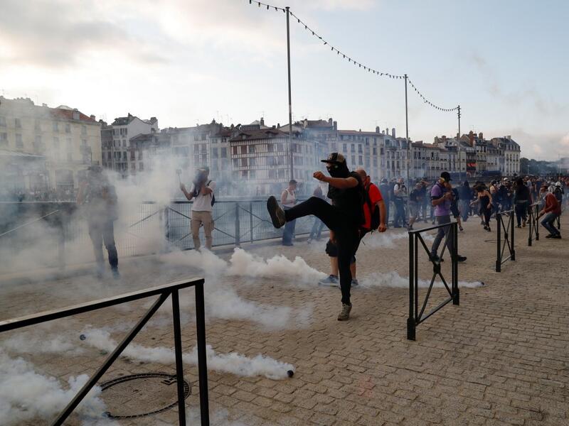 A protester kicks away a 'canister' fired by French security personnel during a demonstration in the city of Bayonne, south-west France on August 24, 2019. Thomas SAMSON / AFP