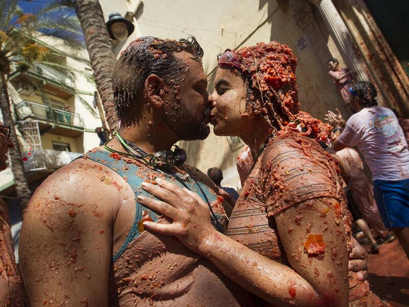 Revellers covered in tomato pulpkiss during the annual "Tomatina" festival in the eastern town of Bunol, on August 28, 2019. JAIME REINA / AFP