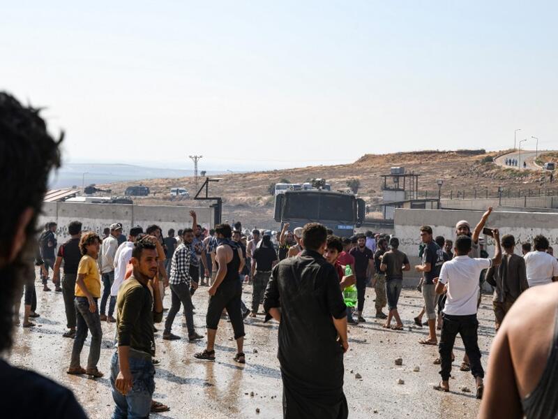 Displaced Syrians demonstrate along the border with Turkey near the town of Atme in the northwestern Idlib province (AFP)