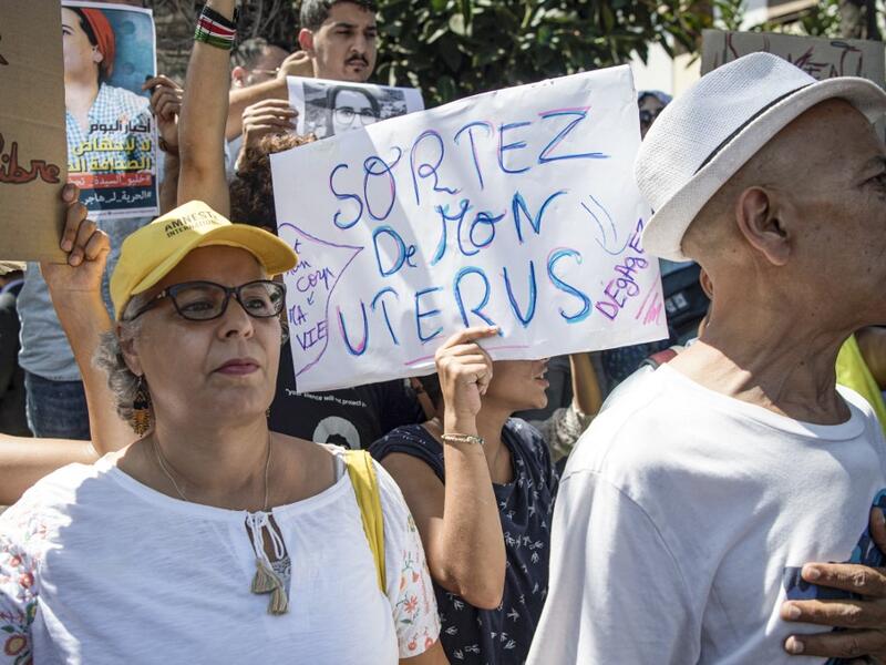 A demonstrator holds up a sign reading in French "get out of my uterus", during a protest outside a courthouse holding the trial of Hajar Raissouni, a Moroccan journalist of the daily newspaper Akhbar El-Youm, on charges of abortion, in the capital Rabat on September 9, 2019. FADEL SENNA / AFP