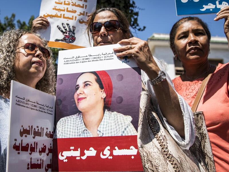 Demonstrators hold up a sign showing the portrait of Hajar Raissouni, a Morrocan journalist of the daily newspaper Akhbar El-Youm, with a caption below in Arabic reading "my body, my freedom", as they gather outside a courthouse holding her trial on charges of abortion in the capital Rabat on September 9, 2019. FADEL SENNA / AFP
