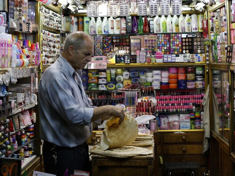 A merchant prepares lunch inside his shop at the Bzourieh market in the centre of the Syrian capital Damascus . The declining value of the pound is a sure sign of Syria's ailing economy. LOUAI BESHARA / AFP