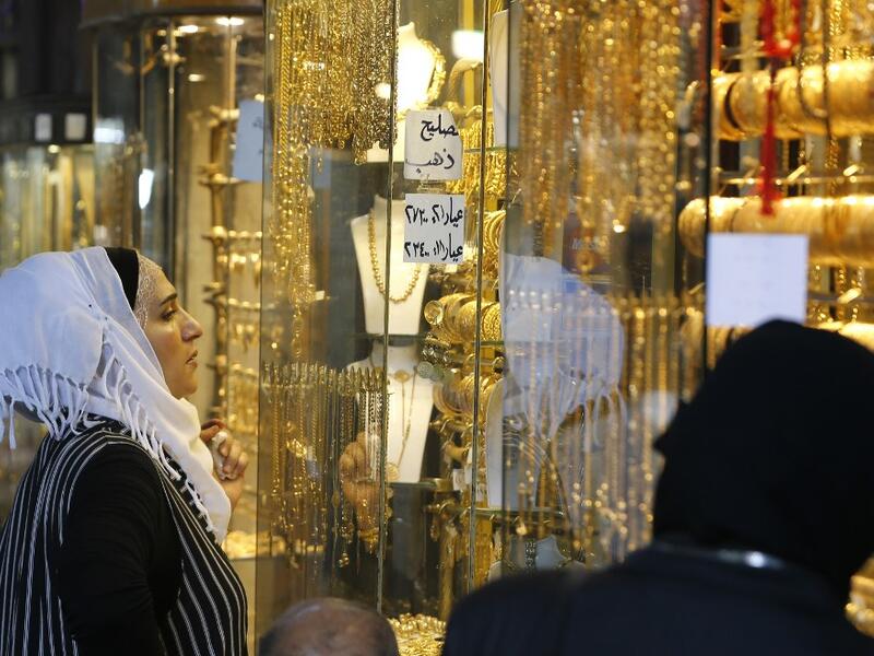 Women gaze at the window of a jewelry shop at the Bzourieh market in the centre of the Syrian.  LOUAI BESHARA / AFP