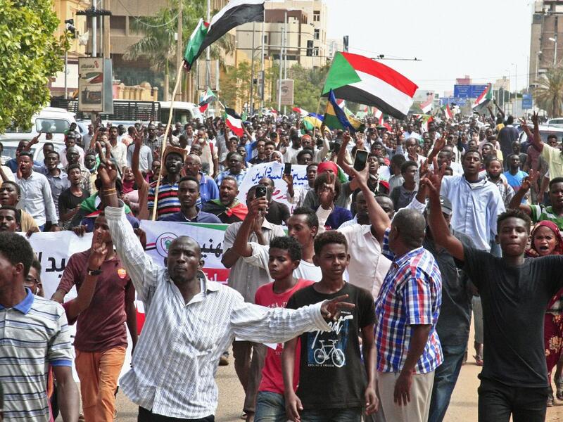 People wave the old and current flags of Sudan as they chant slogans during a mass demonstration near the presidential palace in Sudan's capital Khartoum on September 12, 2019, calling for the appointment of a new permanent chief of judiciary and prosecutor general. (AFP/ File Photo)